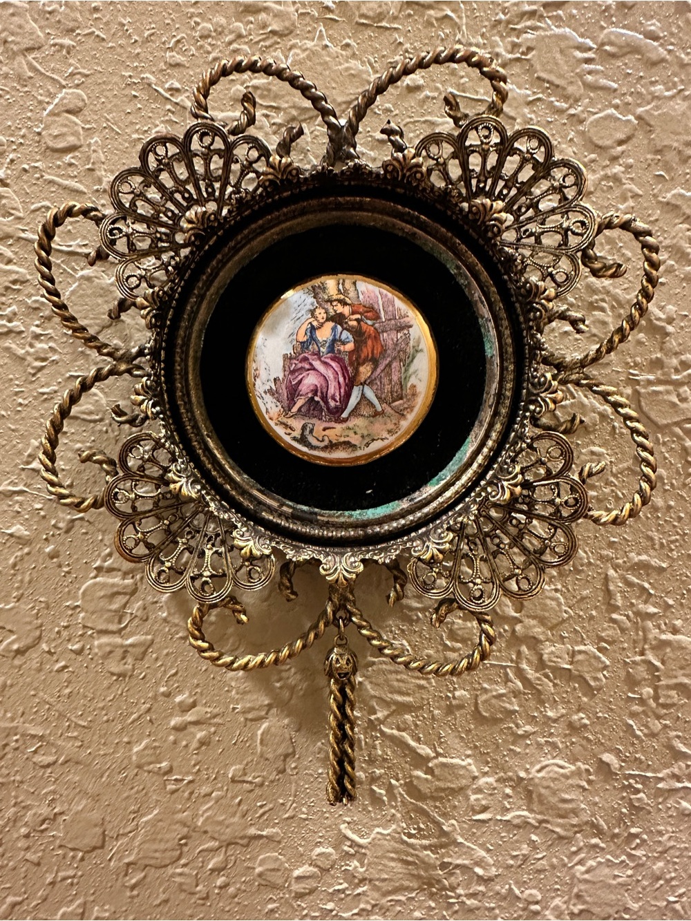 Vintage gold-tone filigree and ormolu wall hanging featuring a central porcelain